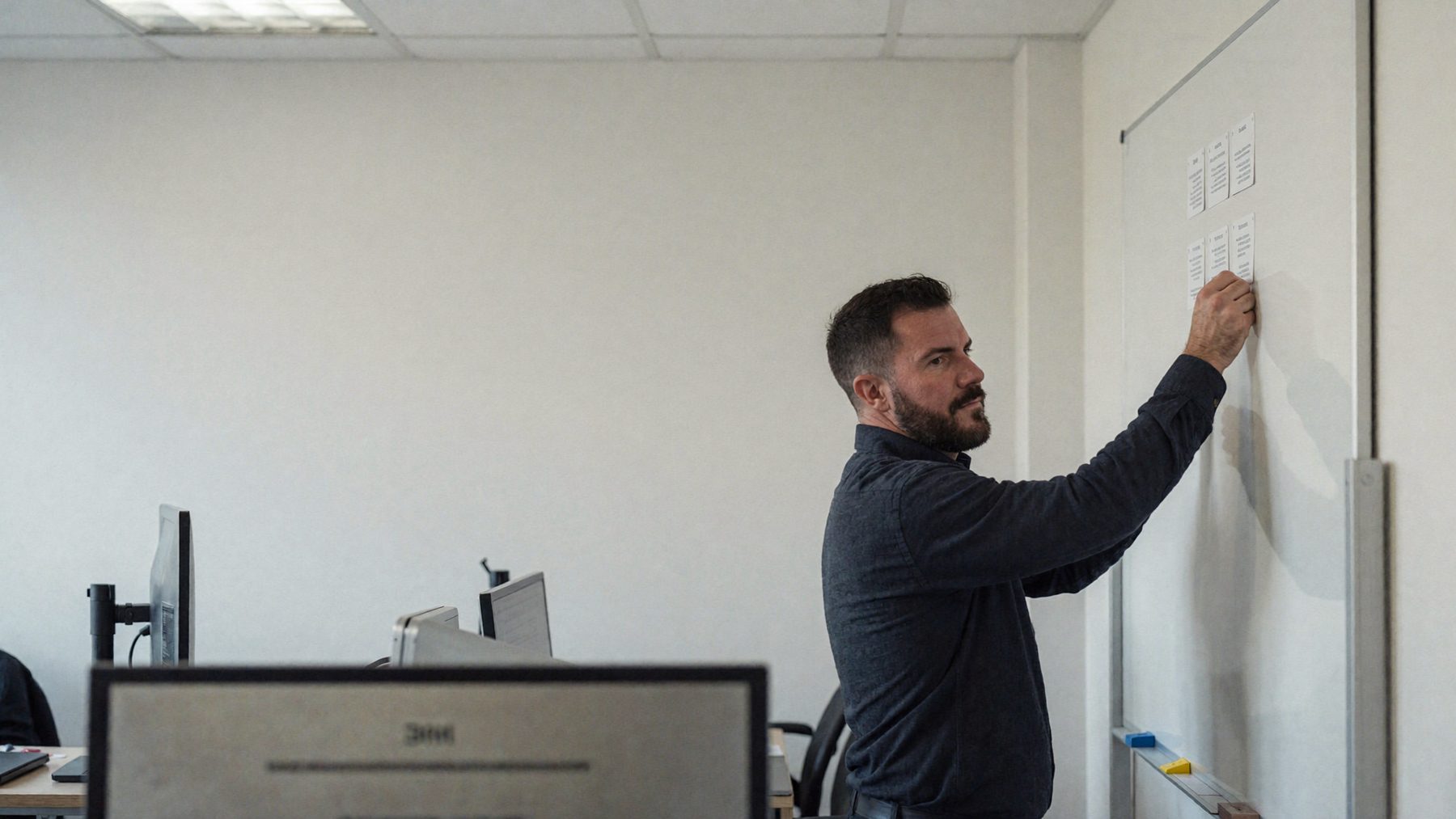 A firm owner placing the last of six paper cards in a column on a wall