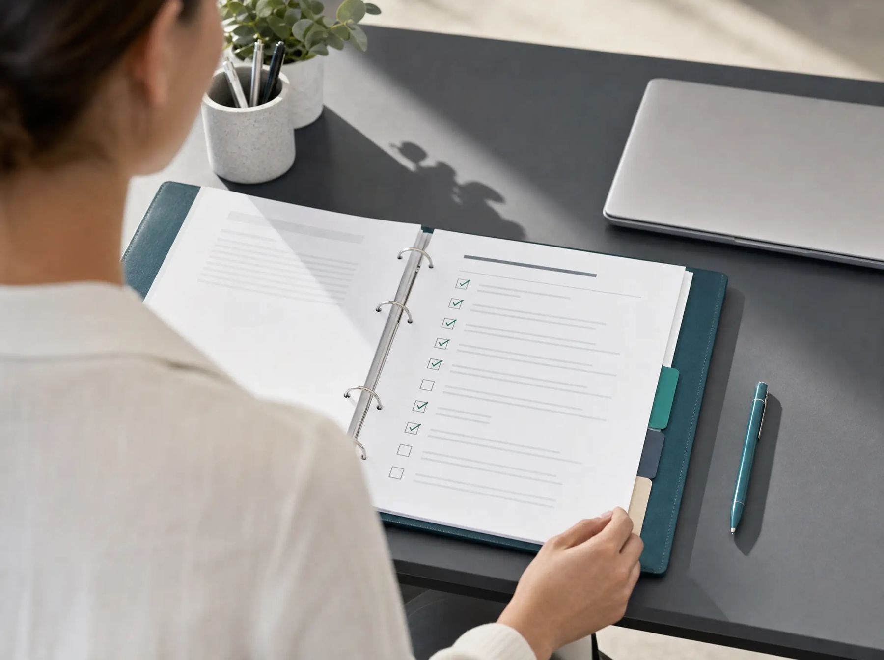 An open handover binder with a checklist and index tabs